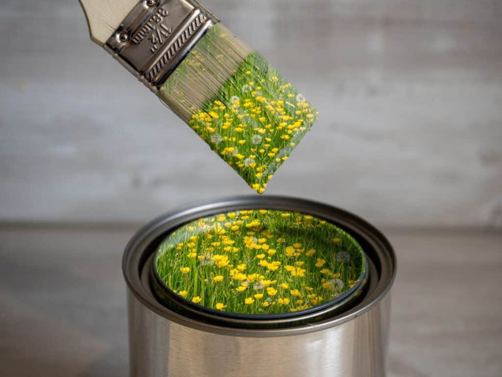 a,can,of,green,wash,paint,with,a,brush,dipped